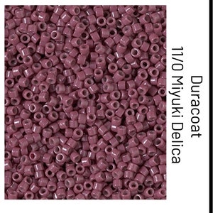 May include: A close-up image of a pile of small, round, opaque, dusty rose-colored beads. The beads are 11/0 size and are made by Miyuki. The beads are labeled "Duracoat".