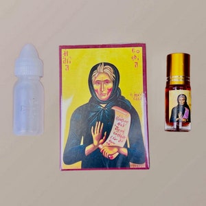 Puede incluir: Un icono rojo y amarillo con una mujer sosteniendo un rollo. El rollo tiene texto en un idioma extranjero. El icono está enmarcado con un borde burdeos. Hay una botella transparente con una tapa blanca y una pequeña botella dorada con un líquido marrón y un pequeño icono.