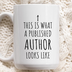 Peut inclure: Une tasse à café en céramique blanche avec une inscription noire qui dit "Ceci est à quoi ressemble un auteur publié" avec une flèche pointant vers le haut.