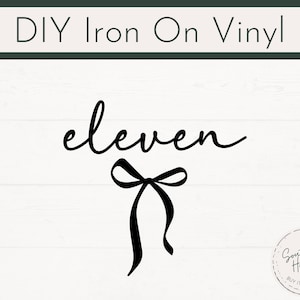 Könnte beinhalten: Schwarzes Bügelvinyl-Design mit dem Wort "eleven" in Schreibschrift und einer Schleifengrafik. Der Text "DIY Iron On Vinyl" steht oben. Ein kreisförmiges Logo mit Text befindet sich in der unteren rechten Ecke.