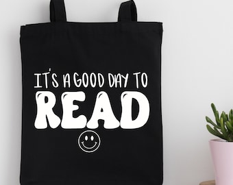 May include: Black tote bag with white text that reads "It's a good day to read" with a smiley face below the text.