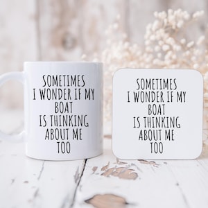 May include: A white ceramic mug and a matching coaster. Both items feature the text "SOMETIMES I WONDER IF MY BOAT IS THINKING ABOUT ME TOO" in black, centered on the surfaces. The mug has a curved handle.