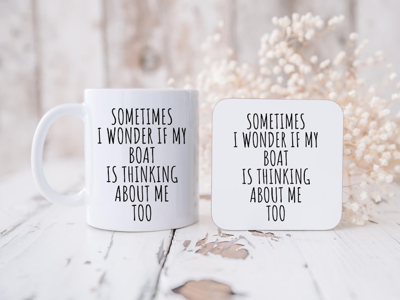 May include: A white ceramic mug and a matching coaster. Both items feature the text "SOMETIMES I WONDER IF MY BOAT IS THINKING ABOUT ME TOO" in black, centered on the surfaces. The mug has a curved handle.