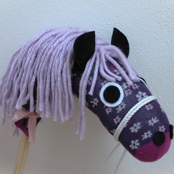 Colorful hobby horse with a wooden handle made from a sock for children