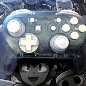 May include: A transparent blue video game controller with white buttons and a white directional pad. The controller has a clear shell, revealing the internal components. The background features a grayscale illustration of video game characters.
