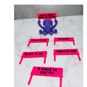 May include: A purple octopus figurine holding a bright pink sign that reads EIGHT ARMS ZERO PATIENCE. Included are four additional pink signs with black text reading You're Clingy, Sucker, Suck it up, TENTA-NO, and 8 ways to say no.