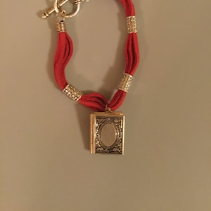 Silver Tone Book Locket Bracelet. Has a Beautiful Book Locket and a Stylish Red Leather Strap and Beads.