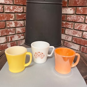 tasses vintage Pyrex et Fire King. A de belles couleurs et dessins. Une belle addition à votre café ou thé. Vendu séparément.