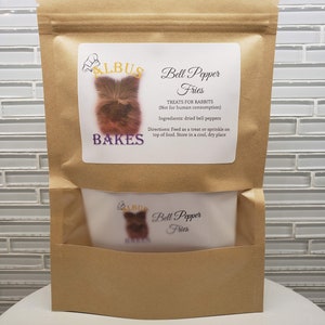 May include: A brown paper bag with a white label that says "Albus Bakes Bell Pepper Fries Treats for Rabbits (Not for human consumption) Ingredients: dried bell peppers Directions: Feed as a treat or sprinkle on top of food. Store in a cool, dry place"