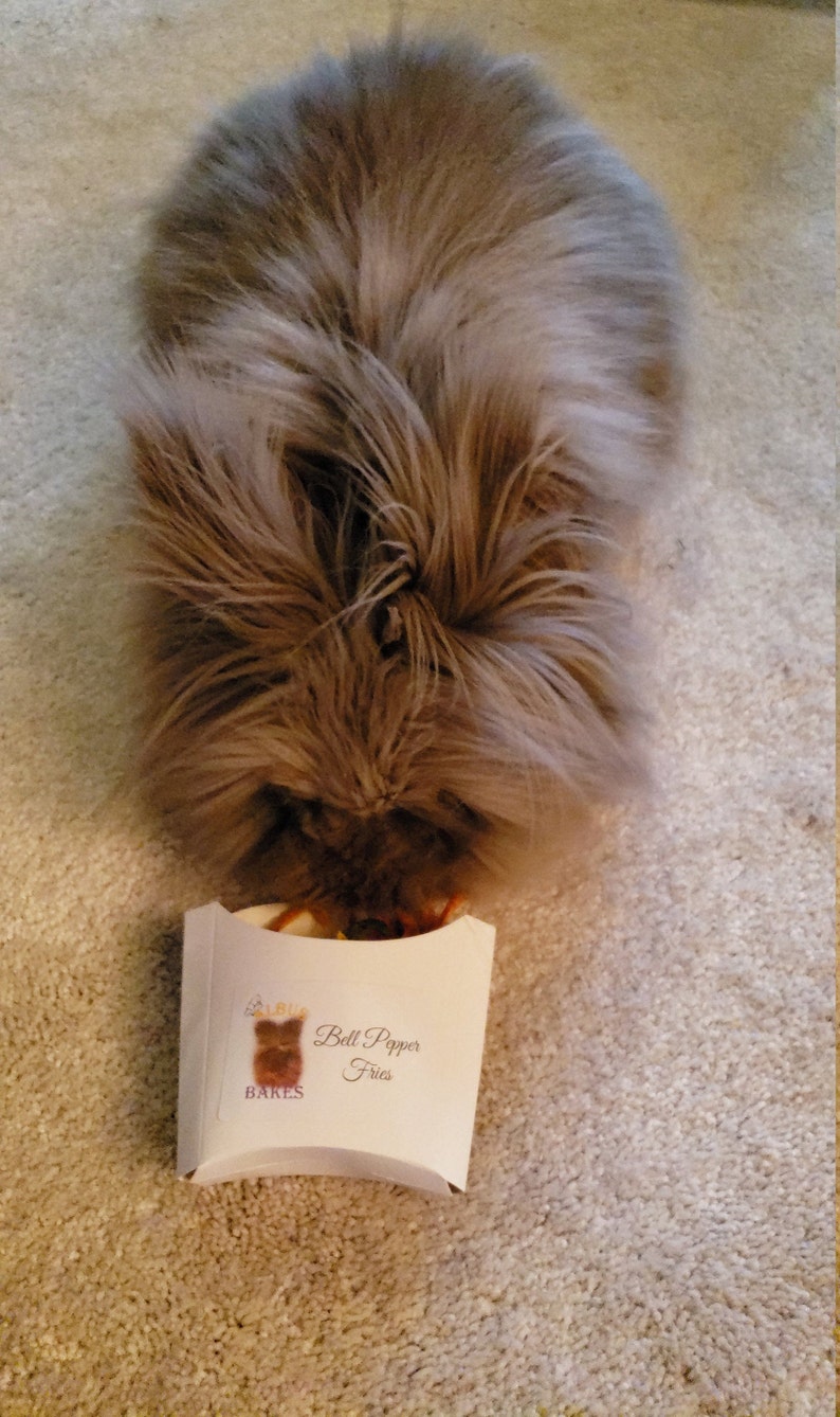 May include: A fluffy brown rabbit is eating from a white paper container with the text "Bell Pepper Fries" and a logo of a bear with the text "BAKES" underneath.
