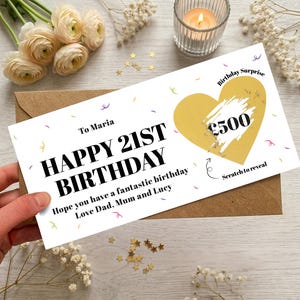 May include: A rectangular white birthday card with black text reading To Maria, HAPPY 21ST BIRTHDAY, and a message from Dad, Mum and Lucy. It features a gold heart with a scratch-off panel revealing £500, confetti graphics, and the text Scratch to reveal.