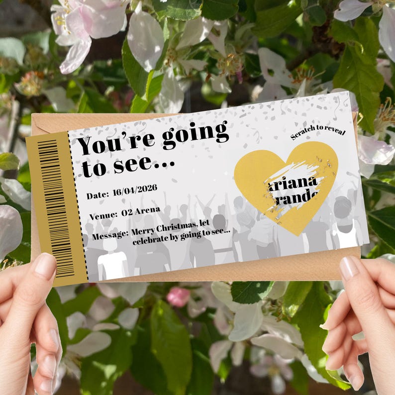 K&ouml;nnte beinhalten: Ein Konzertticket-Design mit dem Text "You're going to see..." und "ariana rande" in einem gelben Herzen. Das Ticket enth&auml;lt das Datum 16.04.2026 und den Veranstaltungsort "O2 Arena". Die Nachricht lautet "Merry Christmas, let celebrate by going to see..."