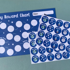 May include: A white ceramic mug with a black handle and the text "But First, Coffee" in a bold, black font. The mug is set against a blurred background, suggesting a cozy setting.