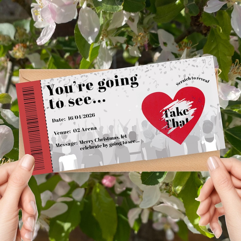 K&ouml;nnte beinhalten: Ein Rubbellos mit dem Text "You're going to see..." und "Take That" in einem roten Herzen. Das Datum ist der 16.04.2026, und der Veranstaltungsort ist 02 Arena. Die Nachricht lautet: Frohe Weihnachten, lasst uns feiern...