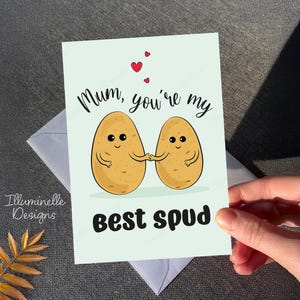 May include: A light blue card with a cute illustration of two potatoes holding hands. The card says "Mum, you're my best spud" with two red hearts in the top corner.