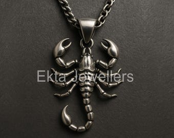 May include: A silver scorpion pendant necklace. The pendant features a detailed scorpion design with claws, legs, and a curved tail. The necklace has a silver chain and the text "Ekta Jewellers".