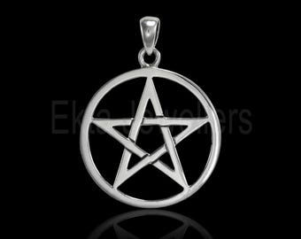 May include: A silver pendant featuring a pentagram within a circle. The pendant has a loop at the top for a chain. The design is symmetrical and the metal has a polished finish. The background is black.