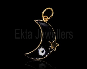 Könnte beinhalten: Goldfarbener Anhänger mit einem schwarzen Halbmond, einem goldenen Stern und einem weiß-schwarzen Augendesign. Der Anhänger hat oben eine Schlaufe für eine Kette. Der Text "Ekta Jewellers" ist sichtbar.
