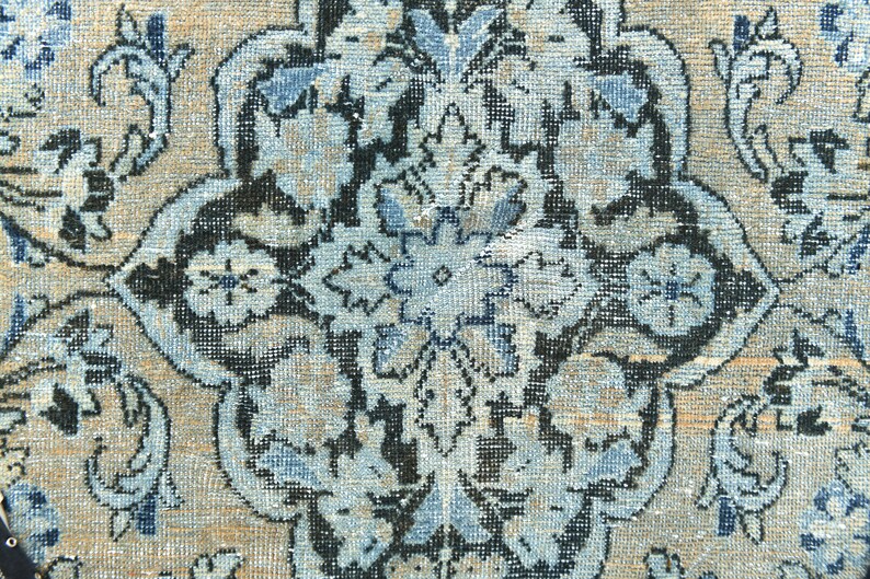 May include: A close-up of a blue and beige patterned rug with intricate floral designs. The rug has a traditional Persian style and features a central medallion.
