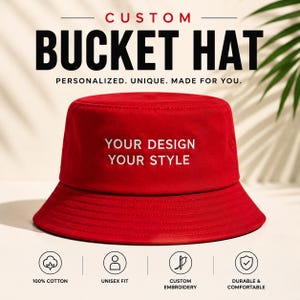 Può includere: Un cappello a secchiello rosso tinta unita con il testo ricamato in bianco "YOUR DESIGN YOUR STYLE" sulla parte anteriore. Il cappello presenta una tesa larga inclinata verso il basso e una parte superiore piatta. Le icone sottostanti indicano 100% cotone, vestibilità unisex, ricamo personalizzato e una struttura resistente e confortevole.