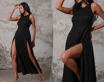 May include: A black maxi dress with a high neckline and two slits on the sides. The dress is made of a soft, flowing fabric.