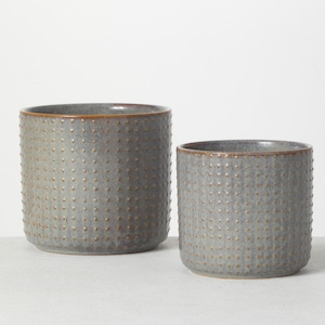 May include: Two gray ceramic planters with a textured dotted pattern. The larger planter is slightly taller than the smaller planter.