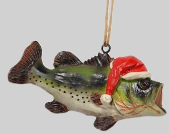 May include: A green and brown bass fish Christmas ornament wearing a red Santa hat.