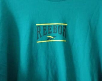 Camiseta Reebok vintage de los 90 para hombre, color verde azulado, manga larga, con logo gráfico y cuello redondo.