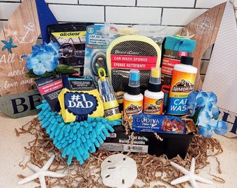 May include: A gift basket filled with car cleaning supplies, including Armor All products, a car wash sponge, microfiber towels, and a #1 Dad sock. Decorative elements include blue flowers, seashells, and nautical-themed wooden cutouts.