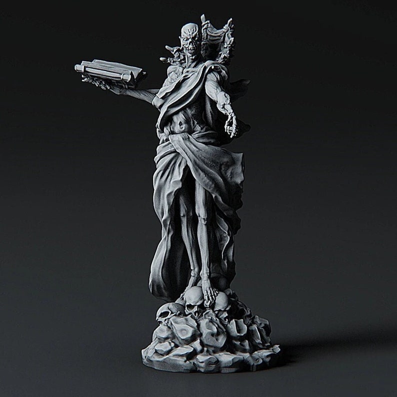 May include: A skeletal figure with a skull-like face stands on a base of skulls. The figure is draped in a flowing robe and holds a book in one hand. The figure is painted in a monochromatic gray color.