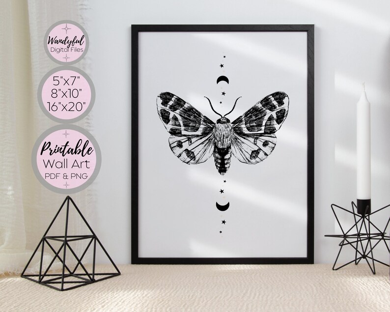 Peut inclure: Impression d'art mural noir et blanc repr&eacute;sentant un papillon de nuit aux ailes d&eacute;ploy&eacute;es et un motif de croissant de lune et d'&eacute;toiles. L'art est disponible en 5x7, 8x10 et 16x20 pouces.