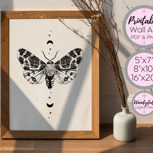 Peut inclure: Un design d'art mural imprimable mettant en sc&egrave;ne une illustration en noir et blanc d'un papillon de nuit avec des croissants de lune et des &eacute;toiles. Le design est disponible en 5x7, 8x10 et 16x20 pouces.