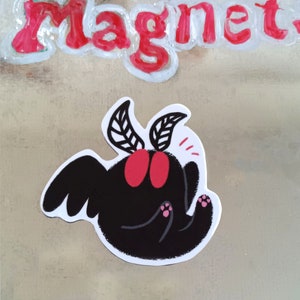 Könnte beinhalten: Eine schwarze und rote Motte mit großen Flügeln und rosa Füßen. Die Motte ist im Cartoon-Stil dargestellt und hat einen überraschten Ausdruck.