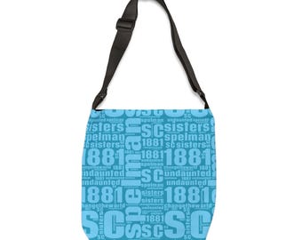 May include: A light blue tote bag with a black adjustable strap. The bag is covered in a repeating pattern of the words "Spelman", "Sisters", "Undaunted", "Change the World", and "1881" in a light blue color.