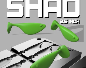 May include: A green plastic mold for making 2.5 inch shad fishing lures. The mold has four cavities and is shown with a green lure in one of the cavities. The mold is made of a durable material and is designed to produce high-quality lures.