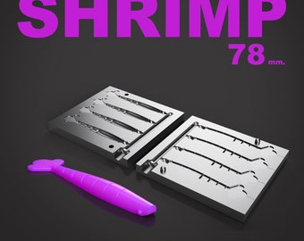 May include: A metal mold for making plastic shrimp lures. The mold is made of two pieces and has six cavities. The mold is 78 mm in size. A purple plastic shrimp lure is also shown.