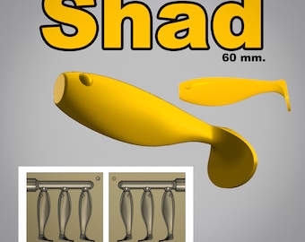 May include: Yellow plastic fishing lure with the word "Shad" in bold yellow letters. The lure is 60 mm long. The image also shows a mold for creating the lure.