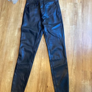 May include: Black leather pants with a slim fit and a zipper fly.
