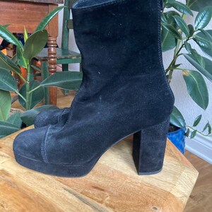 May include: Black suede ankle boots with a chunky platform and block heel.