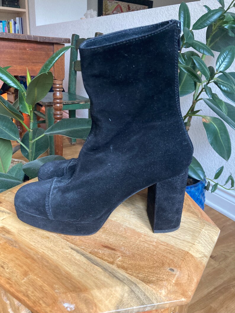 May include: Black suede ankle boots with a chunky platform and block heel.