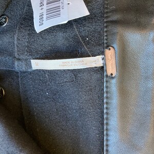 May include: Black leather pants with a Free People label and a size 28 tag. The pants are made in China.