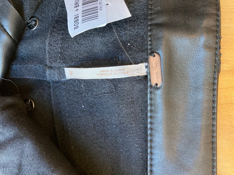 May include: Black leather pants with a Free People label and a size 28 tag. The pants are made in China.