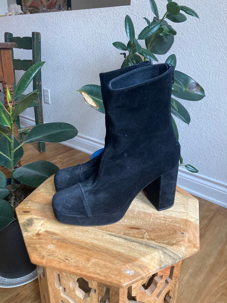 May include: Black suede ankle boots with a chunky platform heel and a zipper on the side.