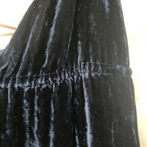 May include: Close-up of a dark blue velvet fabric with a gathered seam.