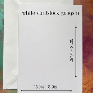 以下が含まれることがあります： 白の封筒と厚紙のセット。厚紙の幅は15cm、高さは21cmです。封筒は120gsm、厚紙は300gsmです。画像は、テクスチャ加工されたカラフルな背景に配置されています。
