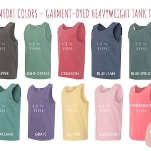 Op de afbeelding: Een verzameling van 10 garment-gekleurde zware tanktops in verschillende kleuren, waaronder peper, lichtgroen, karmijnrood, spijkerblauw, blauwspar, zeeschuim, druif, boter, bloesem en watermeloen. Elk tanktop heeft de tekst "CUS TOM" in een witte ovaal.