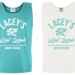 Op de afbeelding: Twee tanktops met een wit grafisch ontwerp met de tekst "Lacey's Last Splash Mount Pocono". Een shirt is turquoise en de andere is wit.