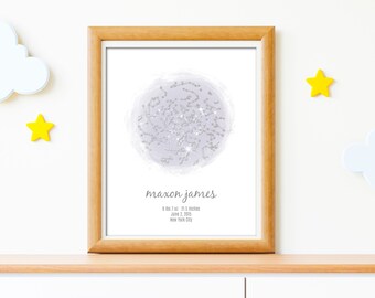 May include: A framed print with a light purple watercolor background and a silver constellation design. The print includes the name "Maxon James" and the date "June 2, 2025" in black text.