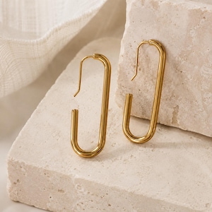 Pendientes minimalistas de aro dorados en forma de U, joyería moderna alargada para el día a día.