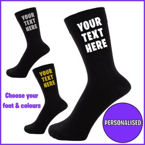 May include: Three pairs of black socks with white text that says "Your Text Here". One pair has yellow text. The socks are personalised.